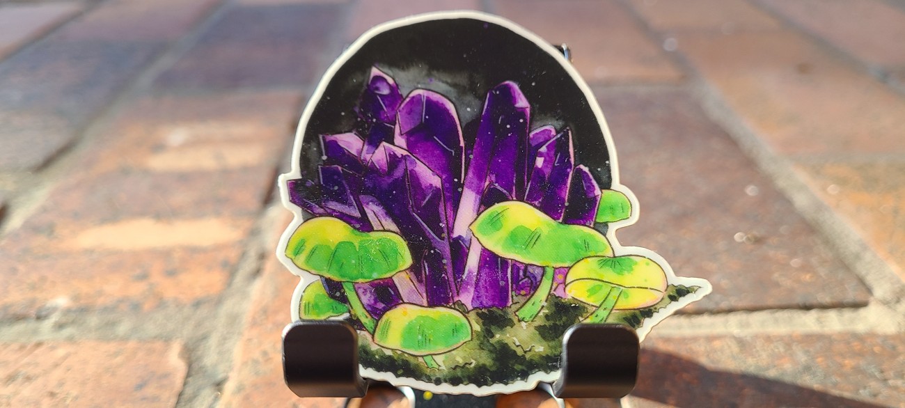 Glowing green mushrooms surround dark purple amethyst on this glow in the dark vinyl sticker