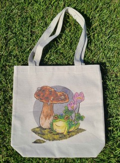 Natural canvas tote bag with my mushroom frog illustration printed across it.