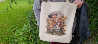 A natural cotton tote bag featuring a Renn Faire or fantasy inspired girl running through oversized mushrooms. She wears a kerchief and a plaid skirt, and her hair is floating behind her.